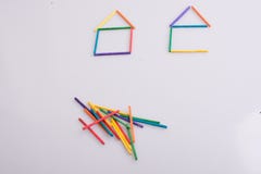 Duas casas feitas de varas coloridas e um grupo das varas de lado fotos de stock Duas casas feitas de varas coloridas e um grupo das varas de lado fotos de stock