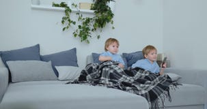 Duas crianças olham um programa televisivo emocionante na tevê Dois irmãos estão olhando a tevê video estoque Duas crianças olham um programa televisivo emocionante na tevê Dois irmãos estão olhando a tevê video estoque