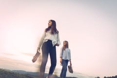 Duas meninas de um ângulo mais baixo com as sapatas em suas mãos imagem de stock Duas meninas de um ângulo mais baixo com as sapatas em suas mãos imagem de stock