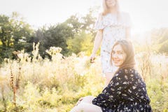 Duas meninas na natureza na grama alta fotografia de stock Duas meninas na natureza na grama alta fotografia de stock