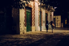 Duas meninas que andam abaixo da rua na noite fotos de stock Duas meninas que andam abaixo da rua na noite fotos de stock