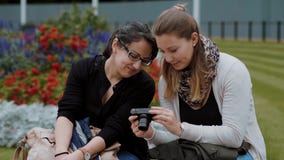 Duas moças relaxam em um parque video estoque Duas moças relaxam em um parque video estoque