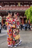 Duas mulheres na roupa japonesa tradicional abraçam-se maciamente no templo de Senso-ji no Tóquio, Japão imagem de stock Duas mulheres na roupa japonesa tradicional abraçam-se maciamente no templo de Senso-ji no Tóquio, Japão imagem de stock