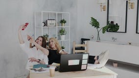 Due amici abbastanza femminili 30s si divertono e si rilassano nel posto di lavoro La donna castana fa il selfie su attimo dello video d archivio Due amici abbastanza femminili 30s si divertono e si rilassano nel posto di lavoro La donna castana fa il selfie su attimo dello video d archivio