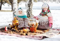 Due bambine in pellicce e scialli nello stile russo sulla sua testa contro lo sfondo di una samovar fotografia stock libera da diritti Due bambine in pellicce e scialli nello stile russo sulla sua testa contro lo sfondo di una samovar fotografia stock libera da diritti