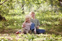 Due bambini felici che ridono fuori nella foresta fotografia stock Due bambini felici che ridono fuori nella foresta fotografia stock