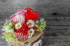Due cuori in un canestro di vimini con le bacche ed i fiori il giorno del ` s del biglietto di S. Valentino in uno stile rustico fotografie stock libere da diritti Due cuori in un canestro di vimini con le bacche ed i fiori il giorno del ` s del biglietto di S. Valentino in uno stile rustico fotografie stock libere da diritti