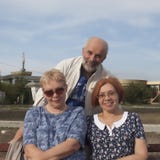 Due donne mature si siedono su un banco, dietro loro un supporto dell'uomo S calda fotografia stock Due donne mature si siedono su un banco, dietro loro un supporto dell'uomo S calda fotografia stock