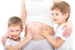 Due figli che abbracciano la madre incinta della pancia Fotografie Stock Due figli che abbracciano la madre incinta della pancia Fotografie Stock