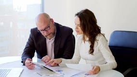 Due genti di affari che lavorano con la compressa Essi che discutono le idee di affari che si siedono sulle sedie nell'ufficio le archivi video Due genti di affari che lavorano con la compressa Essi che discutono le idee di affari che si siedono sulle sedie nell'ufficio le archivi video