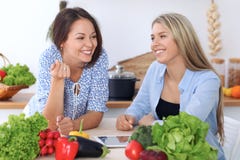 Due giovani donne felici stanno facendo l'acquisto online dal computer della compressa e dalla carta di credito Gli amici stanno fotografia stock Due giovani donne felici stanno facendo l'acquisto online dal computer della compressa e dalla carta di credito Gli amici stanno fotografia stock