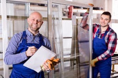 Due lavoratori che ispezionano le finestre Immagine Stock Due lavoratori che ispezionano le finestre Immagine Stock