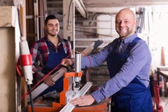 Due lavoratori che lavorano alla macchina Immagine Stock Due lavoratori che lavorano alla macchina Immagine Stock