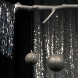 Due palle d'argento d'attaccatura di Natale su fondo scuro e d'argento fotografie stock Due palle d'argento d'attaccatura di Natale su fondo scuro e d'argento fotografie stock