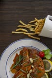 Due pezzi di pollo sono disposti su un piatto bianco e la salsa è versata sul pollo C'è un piatto laterale con le verdure, immagini stock Due pezzi di pollo sono disposti su un piatto bianco e la salsa è versata sul pollo C'è un piatto laterale con le verdure, immagini stock