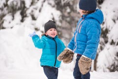 Due ragazzi svegli che giocano fuori in natura di inverno immagini stock Due ragazzi svegli che giocano fuori in natura di inverno immagini stock