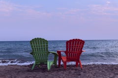 Due sedie di salotto sulla spiaggia Mezzo accenda una chaise-lounge sulla spiaggia fotografia stock Due sedie di salotto sulla spiaggia Mezzo accenda una chaise-lounge sulla spiaggia fotografia stock