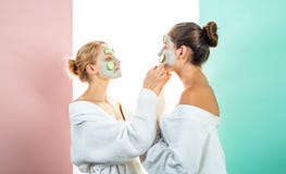 Due sorelle femminili hanno fine settimana alla camera da letto Concezione di cura di pelle usando gli anelli freschi del cetriol immagine stock libera da diritti Due sorelle femminili hanno fine settimana alla camera da letto Concezione di cura di pelle usando gli anelli freschi del cetriol immagine stock libera da diritti