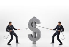 Due uomini d'affari che tirano il grande simbolo di dollaro del calcestruzzo 3d con le corde nelle direzioni opposte isolate su f Fotografie Stock Due uomini d'affari che tirano il grande simbolo di dollaro del calcestruzzo 3d con le corde nelle direzioni opposte isolate su f Fotografie Stock