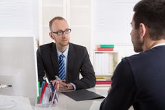 Due uomini di affari che si siedono nell'ufficio: riunione o intervista di lavoro fotografia stock Due uomini di affari che si siedono nell'ufficio: riunione o intervista di lavoro fotografia stock