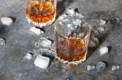 Due vetri antiquati con whiskey ed i cubetti di ghiaccio sul contatore della barra Luce ed ombre dure fotografie stock libere da diritti Due vetri antiquati con whiskey ed i cubetti di ghiaccio sul contatore della barra Luce ed ombre dure fotografie stock libere da diritti