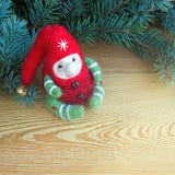 Duende colorido bonito do brinquedo do Natal ao lado dos ramos naturais frescos da árvore de Natal em um fundo de madeira foto de stock Duende colorido bonito do brinquedo do Natal ao lado dos ramos naturais frescos da árvore de Natal em um fundo de madeira foto de stock