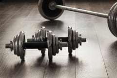 Dumbells pour la forme physique sur le plancher en bois Photo libre de droits Dumbells pour la forme physique sur le plancher en bois Photo libre de droits