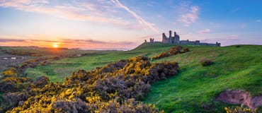 Dunstanburgh-Schloss-Panorama bei Sonnenuntergang lizenzfreie stockfotos Dunstanburgh-Schloss-Panorama bei Sonnenuntergang lizenzfreie stockfotos