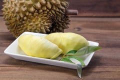 Durian- och Durianblad på den vita maträtten, träbakgrund royaltyfria foton Durian- och Durianblad på den vita maträtten, träbakgrund royaltyfria foton
