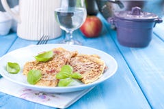 Dutch pancakes with ham for breakfast. Bright colors, blue background. Tasty and caloric. Glass of water. Free space for text royalty free stock images Dutch pancakes with ham for breakfast. Bright colors, blue background. Tasty and caloric. Glass of water. Free space for text royalty free stock images