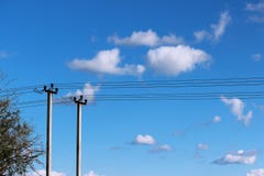 Dwa betonowego filaru i elektrycznego drewnianego słup przeciw chmurom i niebieskiemu niebu zdjęcia royalty free Dwa betonowego filaru i elektrycznego drewnianego słup przeciw chmurom i niebieskiemu niebu zdjęcia royalty free