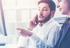Dwa biznesmena w biurze na telefonie komórkowym zdjęcie stock Dwa biznesmena w biurze na telefonie komórkowym zdjęcie stock