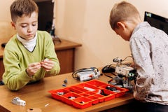 Dwa mÄ…drze chÅ‚opiec robiÄ… robotom od mechanicznego konstruktora przy biurkiem z komputerem w szkole robotyka obraz stock Dwa mÄ…drze chÅ‚opiec robiÄ… robotom od mechanicznego konstruktora przy biurkiem z komputerem w szkole robotyka obraz stock
