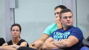 Dwa mężczyzna i kobiety obsiadania w gym na szkoleniu zbiory Dwa mężczyzna i kobiety obsiadania w gym na szkoleniu zbiory