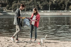 Dwa młodego promieniejącego ucznia stoi blisko rzeki podczas gdy czyścić piasek fotografia royalty free Dwa młodego promieniejącego ucznia stoi blisko rzeki podczas gdy czyścić piasek fotografia royalty free