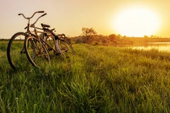 Dwa rower blisko jeziornego zmierzchu tła Dwa rocznika bicyklu przy zmierzchem Pojęcie romans i miłość obraz stock Dwa rower blisko jeziornego zmierzchu tła Dwa rocznika bicyklu przy zmierzchem Pojęcie romans i miłość obraz stock