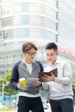 Dwa uśmiechniętego męskiego pracy coworkers outdoors opowiada wpólnie nad a zdjęcia stock Dwa uśmiechniętego męskiego pracy coworkers outdoors opowiada wpólnie nad a zdjęcia stock
