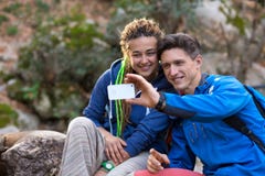 Dwa wycieczkowicza mężczyzna i dziewczyna bierze fotografię z przenośnym telefonem zdjęcie stock Dwa wycieczkowicza mężczyzna i dziewczyna bierze fotografię z przenośnym telefonem zdjęcie stock