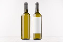 Dwa zielonej wino butelki z pustą białą etykietką bez etykietki i, na białej drewnianej desce, wyśmiewają up Zdjęcie Stock Dwa zielonej wino butelki z pustą białą etykietką bez etykietki i, na białej drewnianej desce, wyśmiewają up Zdjęcie Stock