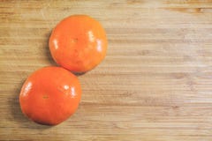 Dwa świeży tangerine strugający na drewnianej desce fotografia royalty free Dwa świeży tangerine strugający na drewnianej desce fotografia royalty free
