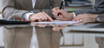 Dwa żeńskiego księgowego liczy na kalkulatora dochodzie dla podatek formy ukończenia, ręki zbliżenie Urząd skarbowy obrazy stock Dwa żeńskiego księgowego liczy na kalkulatora dochodzie dla podatek formy ukończenia, ręki zbliżenie Urząd skarbowy obrazy stock