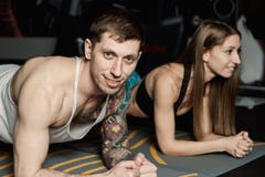 Dysponowany sportive mężczyzna i kobieta robi deski sedna ćwiczenia szkoleniu popieramy mięśnia pojęcia gym sporta sportowa spraw obrazy royalty free Dysponowany sportive mężczyzna i kobieta robi deski sedna ćwiczenia szkoleniu popieramy mięśnia pojęcia gym sporta sportowa spraw obrazy royalty free