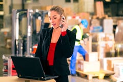 Dyspozytor używa telefon przy magazynem spedycja zdjęcia stock Dyspozytor używa telefon przy magazynem spedycja zdjęcia stock