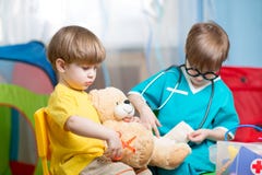 Dzieci bawić się doktorski w domu i leczyć mokiet zabawkę zdjęcia stock Dzieci bawić się doktorski w domu i leczyć mokiet zabawkę zdjęcia stock