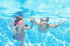 Dzieci pływają w basenie podwodnym, szczęśliwe aktywne dziewczyny zabawę pod wodą, dzieciak sprawnością fizyczną i sportem na rod zdjęcie royalty free Dzieci pływają w basenie podwodnym, szczęśliwe aktywne dziewczyny zabawę pod wodą, dzieciak sprawnością fizyczną i sportem na rod zdjęcie royalty free
