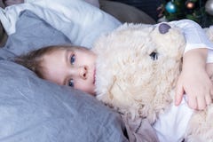 dziecka niedźwiadkowy przytulenia miś pluszowy Troszkę kłama z jej oczami otwartymi dziewczyna z blondynem w łóżku zdjęcia stock dziecka niedźwiadkowy przytulenia miś pluszowy Troszkę kłama z jej oczami otwartymi dziewczyna z blondynem w łóżku zdjęcia stock