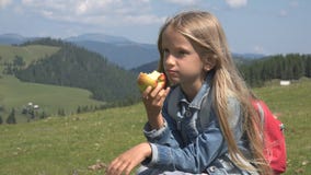 Dziecka łasowania jabłka w górach, Głodny dzieciak przy pinkinem, mała dziewczynka przy campingiem fotografia royalty free Dziecka łasowania jabłka w górach, Głodny dzieciak przy pinkinem, mała dziewczynka przy campingiem fotografia royalty free