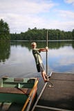 Dziecko Bawić się na doku Łowić rząd łódź na Małym jeziorze w Północnych drewnach obrazy stock Dziecko Bawić się na doku Łowić rząd łódź na Małym jeziorze w Północnych drewnach obrazy stock