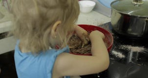 Dziecko miesza czekoladowego ciasto, dziewczyna robi tortowi w kuchni zbiory wideo Dziecko miesza czekoladowego ciasto, dziewczyna robi tortowi w kuchni zbiory wideo