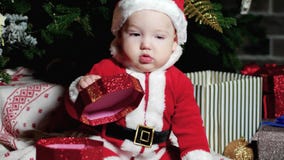 Dziecko w Santa kostiumu, Święty Mikołaj chłopiec, dziecko siedzi w karnawałowych kostiumach, Bożenarodzeniowi kostiumy pod bożym zbiory wideo Dziecko w Santa kostiumu, Święty Mikołaj chłopiec, dziecko siedzi w karnawałowych kostiumach, Bożenarodzeniowi kostiumy pod bożym zbiory wideo